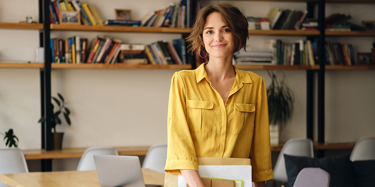 Woman in yellow blouse standing in an office