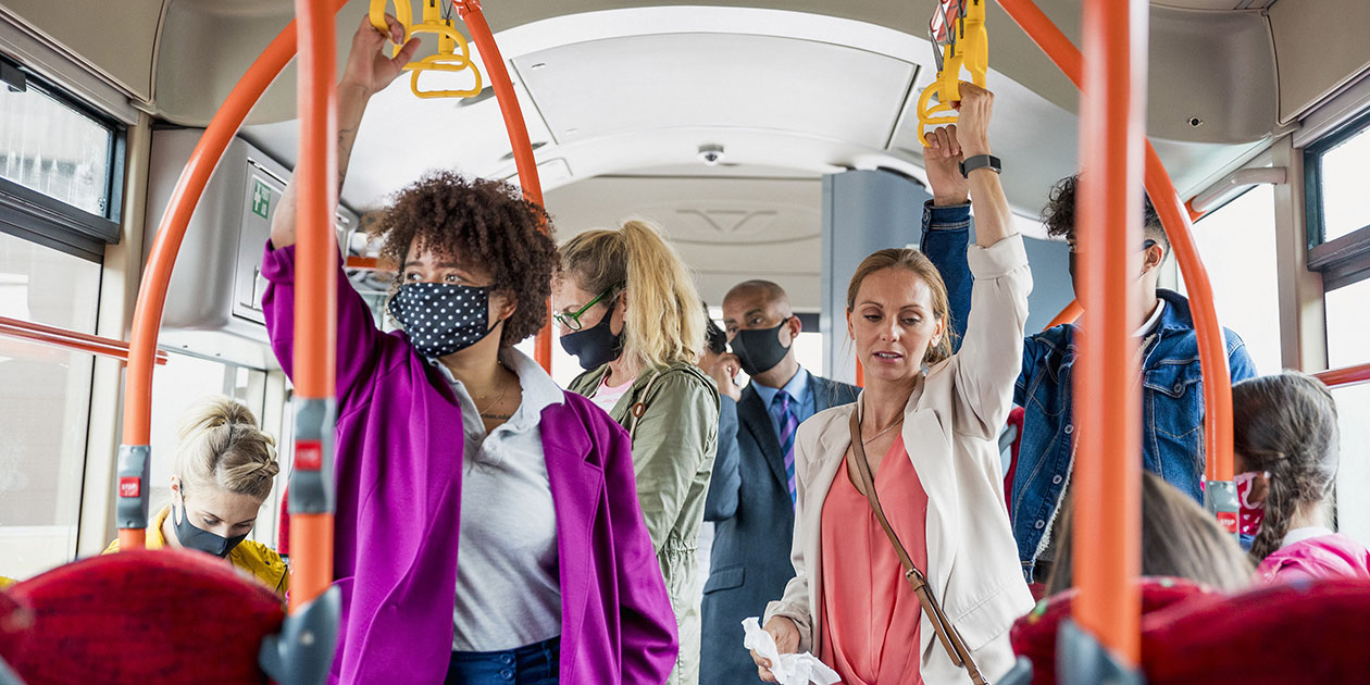 A crowded bus with people in masks
